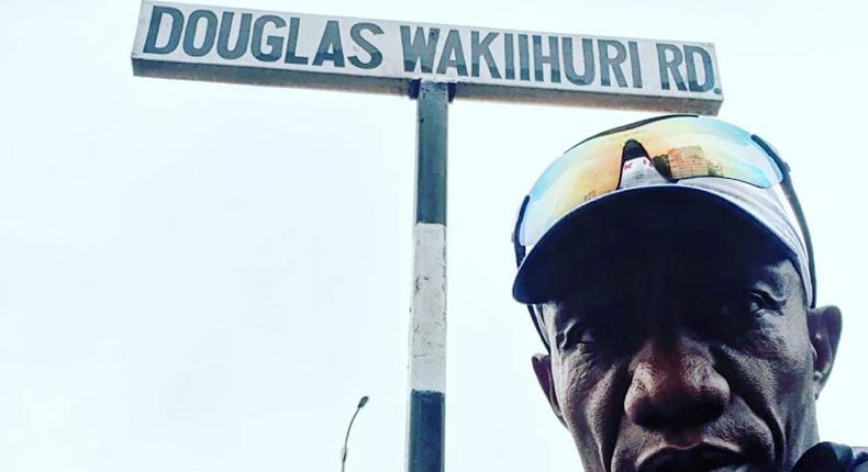 Kenya's marathon legend Douglas Wakiihuri poses next to the sign for the road that was formerly Aerodrome Road at Nyayo National Stadium on March 31, 2022, which has now been renamed Douglas Wakiihuri Road in honour of Kenya's first world marathon champion.