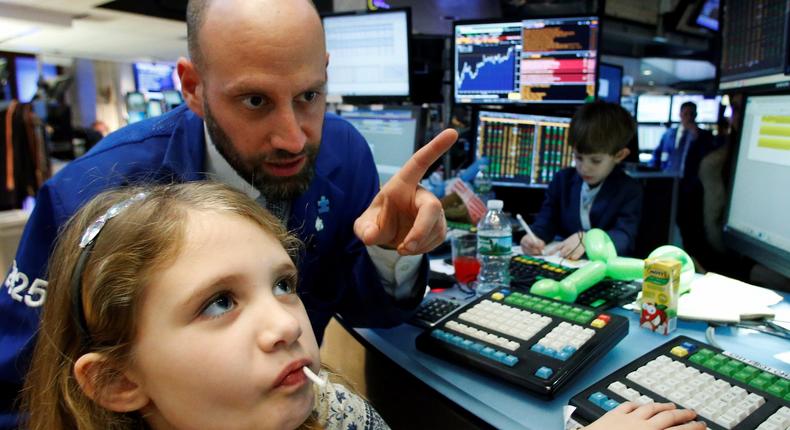 Specialist trader Meric Greenbaum works with his daughter on the floor of the New York Stock Exchange (NYSE) in New York City, U.S., November 25, 2016.