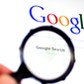 Hand holds Magnifying glass against Google homepage