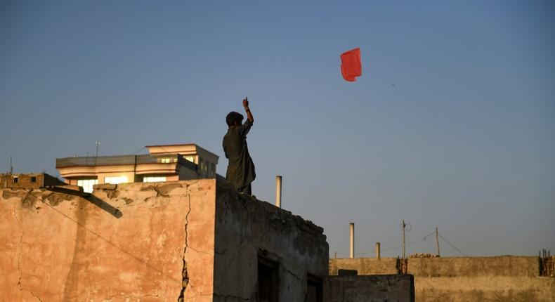 An Afghan boy flies a kite from the rooftop of a house in Mazar-i-Sharif. Young people are sceptical a deal with the Taliban will bring lasting peace