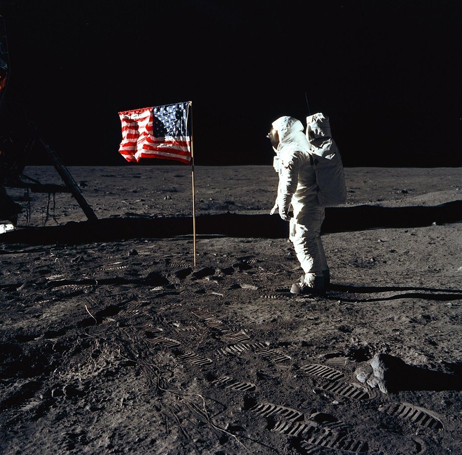 Astronauta Edwin E. Aldrin Jr., pilot modułu księżycowego Apollo 11 pozuje do fotografii obok flagi USA.