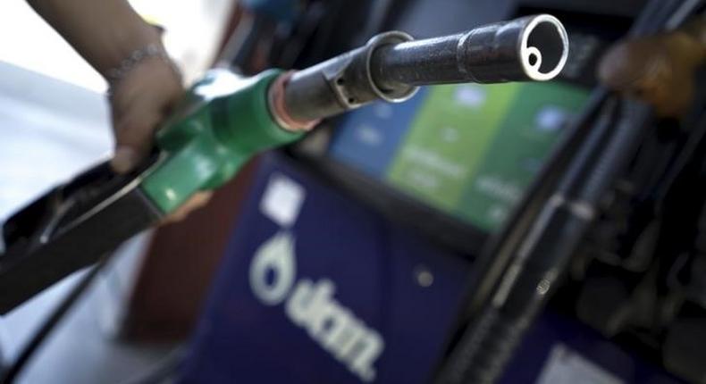 A worker grabs a nozzle at a PTT gas station in Bangkok, Thailand, January 5, 2016. REUTERS/Athit Perawongmetha