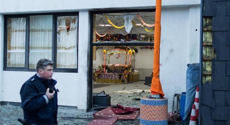 A police officer walks in front of the Sikh temple in Essen, western Germany, where an explosion took place at a wedding on April 16.