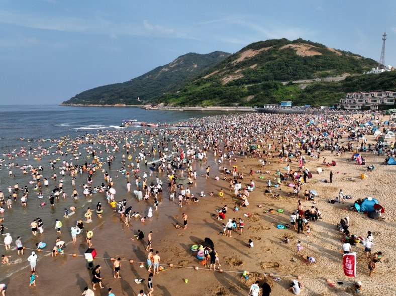 Turyści chłodzą się na plaży Dashawan w mieście Lianyungang we wschodniochińskiej prowincji Jiangsu