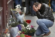 A man pays his respect outside the Le Carillon restaurant the morning after a series of deadly attacks in Paris