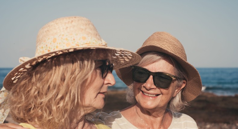 Two women enjoy the sun while wearing their hatslucigerma/Getty Images