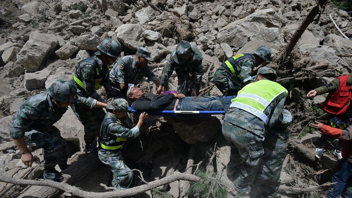 Chinese paramilitary police carry a survivor after an earthquake in Jiuzhaigou county