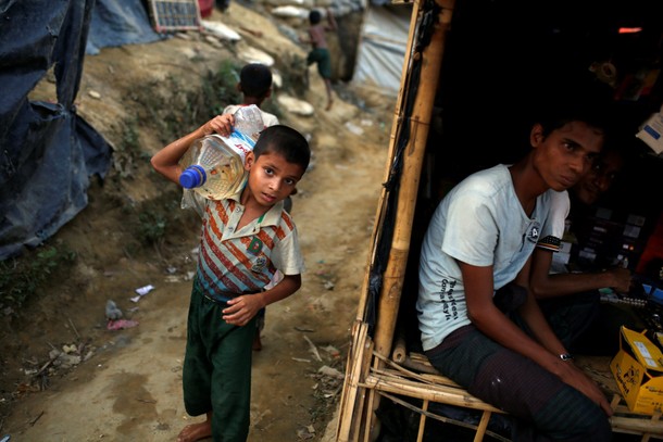 A Rohingya refugee boy carries a bottle of water at the Balukhali refugee camp near Cox's Bazar