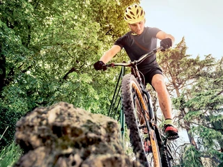 Sport guy making downhill on his mountain bike