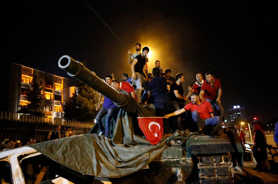 People stand on a Turkish army tank in Ankara, Turkey, July 16, 2016.