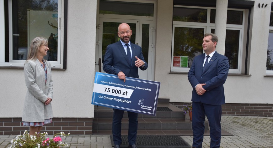 Jacek Sutryk, prezydent Wrocławia, z symbolicznym czekiem na kwotę 75 tys. Pieniądze te pozwoliły wyremontować dach Gminnego Ośrodka Kultury w Międzyborzu.