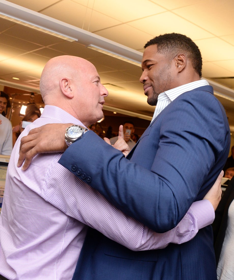 Michael Strahan hugs BTIG's Steven Starker.