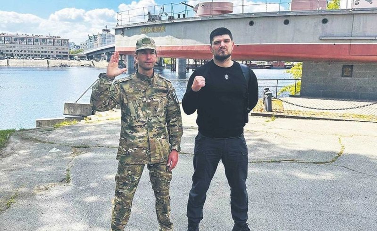 „Cezar” z legionu „Wolność Rosji” i Dienis Kapustin vel Nikitin z Rosyjskiego Korpusu Ochotniczego na terenie stoczni w Kijowie na tle radzieckiego okrętu „Żelezniakow” z czasów II wojny światowej