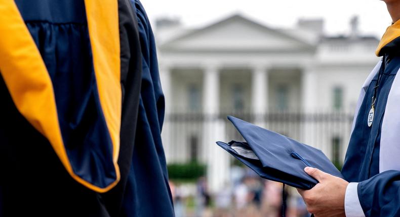 Students from George Washington University wear their graduation gowns outside of the White House in Washington, DC, on May 18, 2022Stefani Reynolds / AFP)