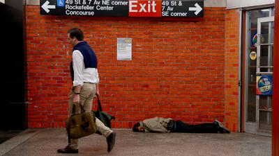Bezdomny śpiący na stacji metra na Manhattanie