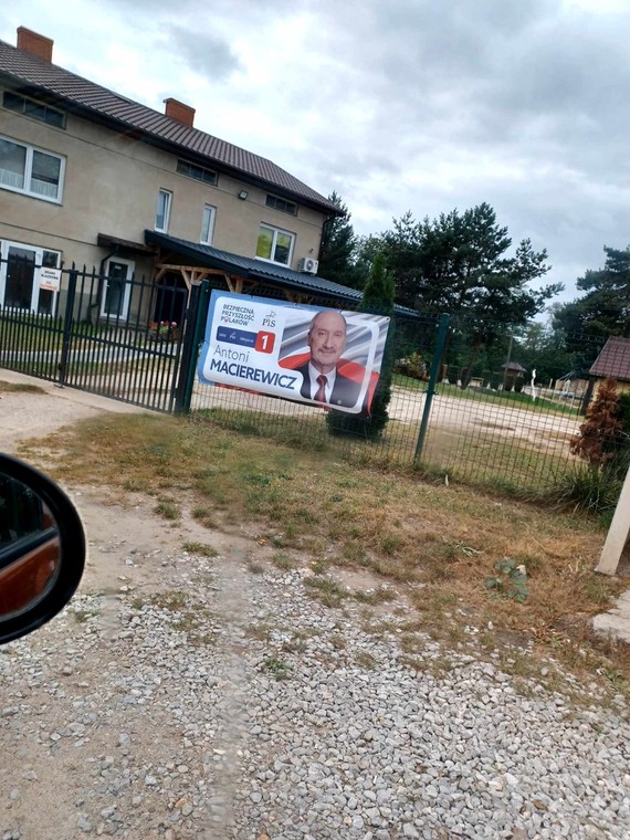 Plakat posła PiS Antoniego Macierewicza na płocie przy parafii w Jeruzalu Skierniewickim