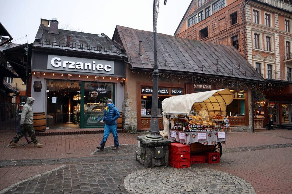 Ludzie spacerują i popijają grzańce. Niektórzy przechadzają się bez maseczek 