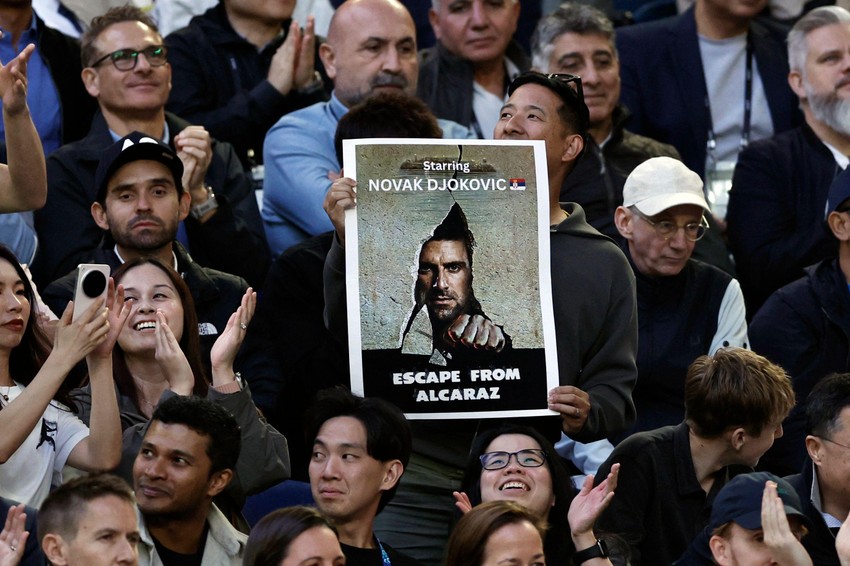 Đokovićev navijač u Melburnu drži zanimljiv transparent: Fotografija Novaka kao plakat za film i poruka: Bekstvo od Alkaraza | Foto: REUTERS/Tingshu Wang