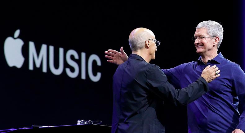 Apple CEO Tim Cook, right, hugs Beats by Dre cofounder and Apple employee Jimmy Iovine.