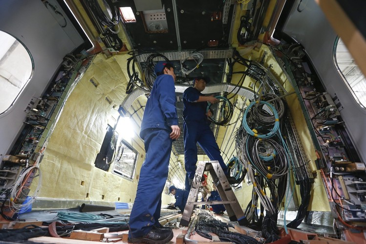 Montownia Tangshan Railway Vehicle, <br><b>Na zdjęciu: </b>Technicy pracują wewnątrz pociągu w montowni w Tangshan Railway Vehicle Co. Ltd. (TRC) <br><br> fot. EPA / ROLEX DELA PENA DOSTAWCA: PAP / EPA.