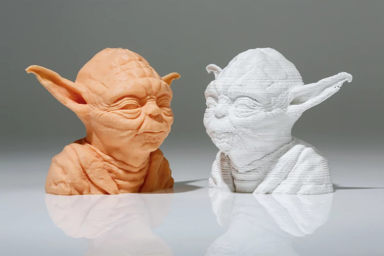 Yoda z taniej drukarki 3D (po prawej) sprawia wrażenie zgrubnego szkicu, wydruk był gotowy po 90 minutach. Ultimaker 3 wygenerował wierną kopię (po lewej) z wieloma detalami, ale potrzebował do tego prawie trzech godzin