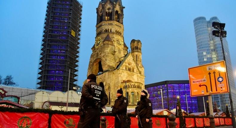 Policemen stand on December 20, 2016 in front of the Kaiser-Wilhelm-Gedaechtniskirche in Berlin, where a truck crashed the day before into a Christmas market