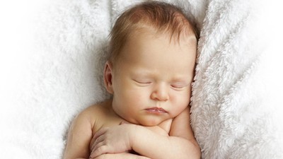 newborn baby sleeping on a white blanket