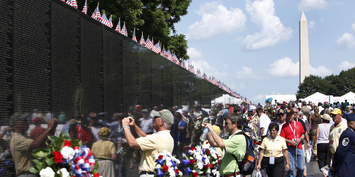 People visit the Vietnam Veterans Memorial wall, etched with the names of more than 58,000 U.S. servicemen and women who died in the war, on Memorial Day in Washington May 28, 2012.
