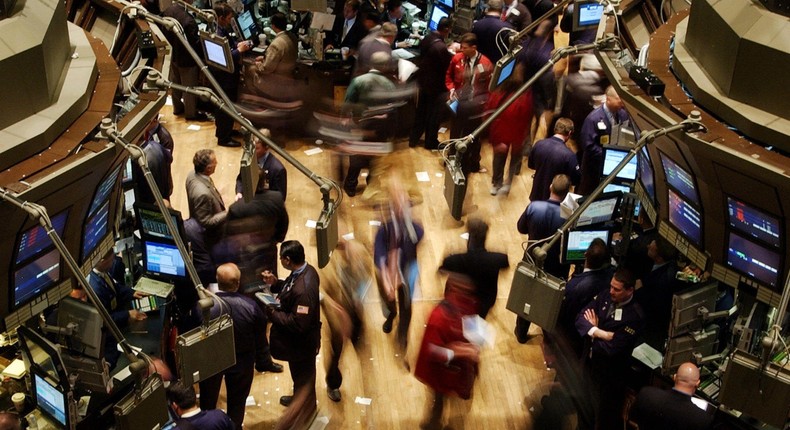 Traders working on the floor of the New York Stock Exchange are blur in this time exposure, just before the opening bell, 11 May, 2004.