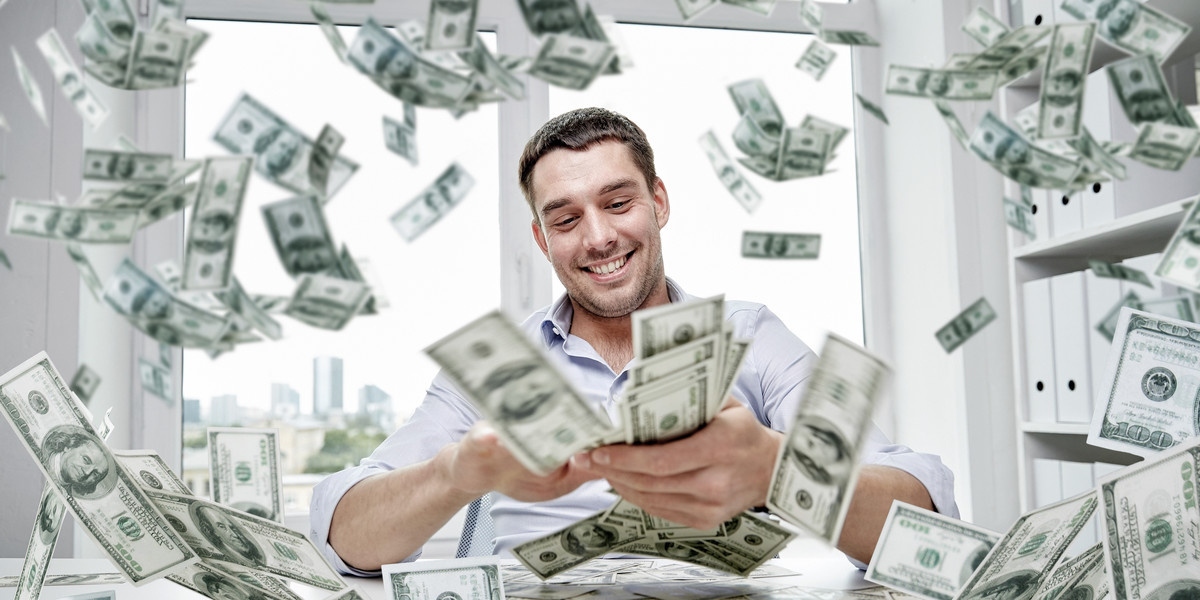 happy businessman with heap of money