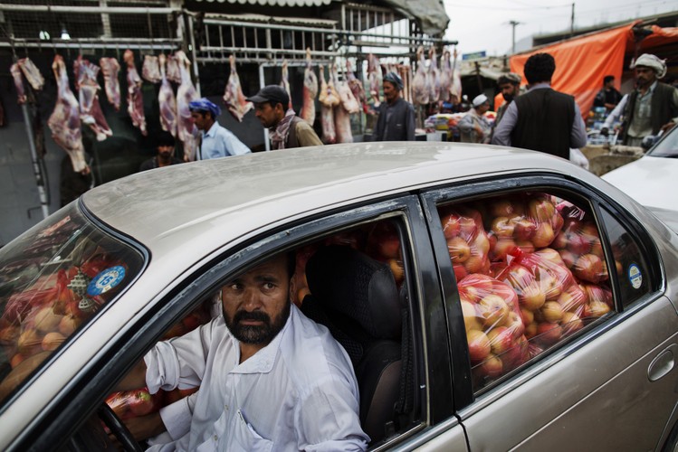 Kierowca samochodu ,załadowanego pod sam dach jabłkami , stoi w korku w pobliżu giełdy warzywno-owocowej w Kabulu w Afganistanie. W lutym 2013 roku w swoim orędziu Barack Obama zapowiedział <a href='http://forsal.pl/artykuly/717267,amerykanskie-oddzialy-moga-szybciej-opuscic-afganistan.html'>wycofanie 34 tysięcy amerykańskich żołnierzy z Afganistanu</a> i zakończenie wojny w tym regionie do końca 2014 roku. Fot. Victor J. Blue/ Bloomberg's Best Photos 2013