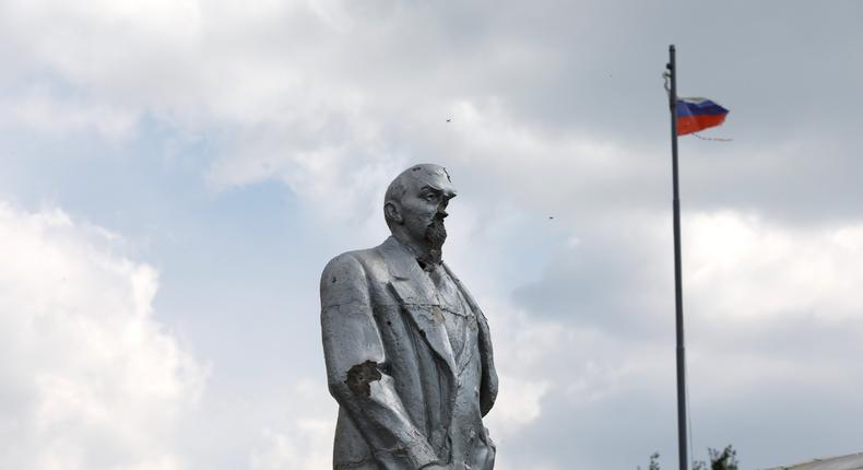 A statue of Vladimir Lenin in the Russian town of Sudzha was damaged by fighting as a tattered Russian flag billows in the background.KIRILL CHUBOTIN / Ukrinform/Future Publishing via Getty Images