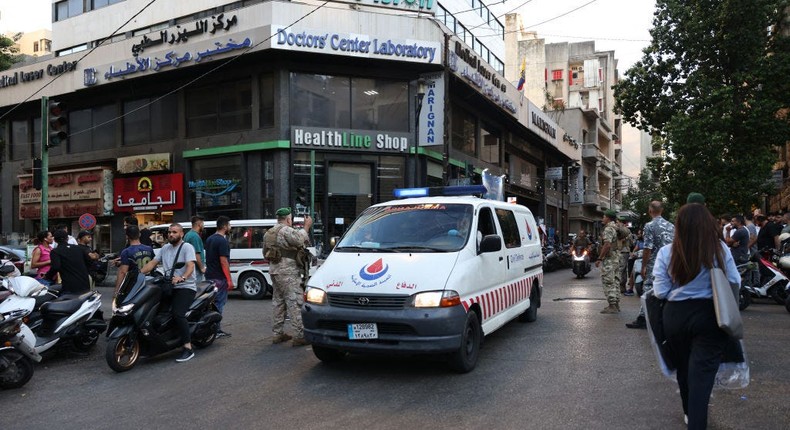 Lebanese army soldiers stand guard as an ambulance rushes wounded people to a hospital in Beirut on September 17, 2024.ANWAR AMRO/AFP via Getty Images