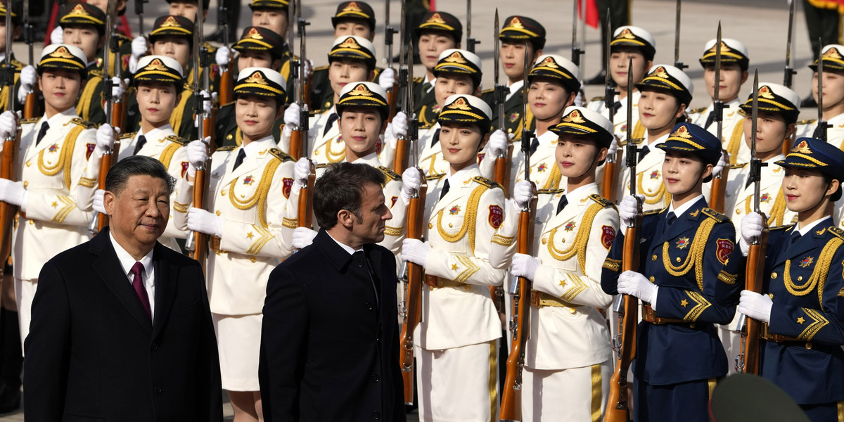 Prezydent Francji Emmanuel Macron dokonuje inspekcji gwardii honorowej wraz z prezydentem Chin Xi Jinpingiem podczas ceremonii powitalnej przed Wielką Salą Ludową, 6 kwietnia 2023 r. w