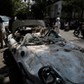 People are seen next to a damaged car after an earthquake in Mexico City