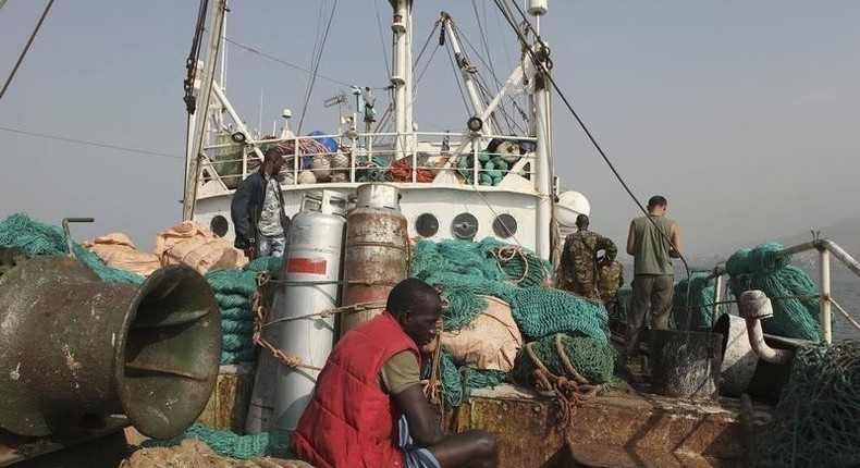 A crew member sits on a fishing net as Sierra Leonean security forces guard the Marampa 803, a vessel apprehended for alleged illegal fishing activities, that has been moored off the West African country's capital Freetown January 21, 2012. 