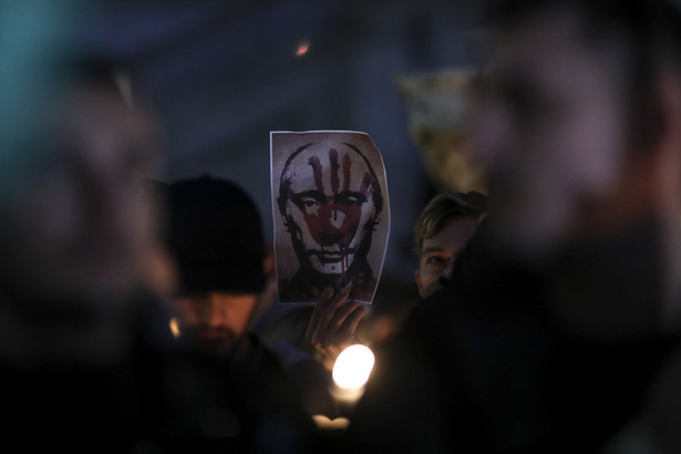 Demonstrators hold placards, featuring images of Russia's President Vladimir Putin, during a candlelit march to show support for people of Ukraine, from the town hall to the Colosseum, in Rome, Italy, on Friday, Feb. 25, 2022. Around the world, people gathered in groups that numbered from the dozens to the thousands to express support for the people of Ukraine. Photographer: Alessia Pierdomenico/Bloomberg