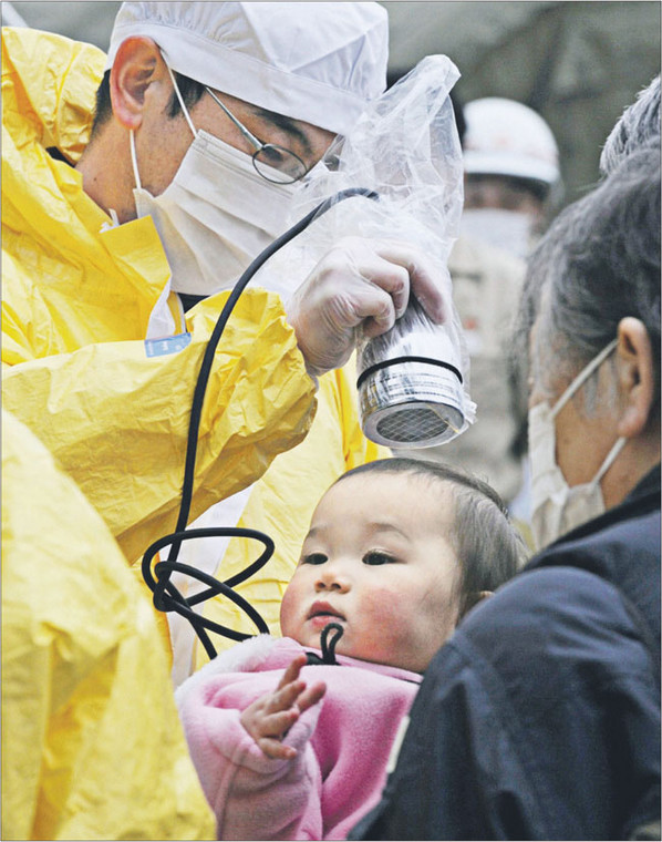 Japońskie służby badają mieszkańców zagrożonych terenów, czy nie zostali napromieniowani po wybuchu w elektrowni Fukushima Fot. REUTERS/FORUM
