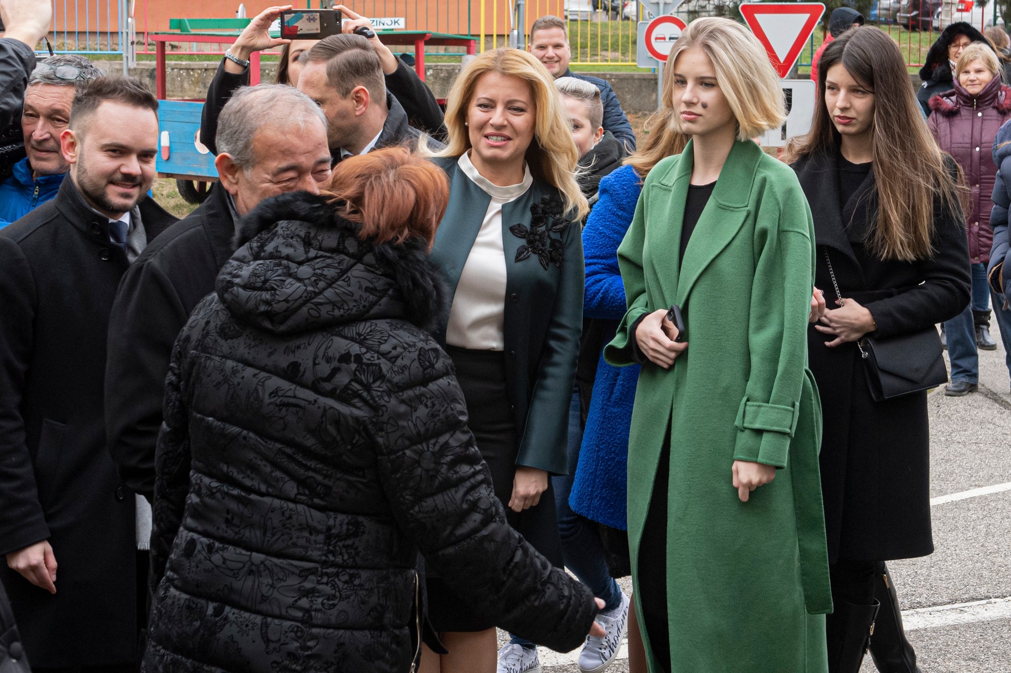 Čaputová čaká s dcérami Leou (vpravo) a Emou (druhá vpravo) pred volebnou miestnosťou vo voľbách do Národnej rady SR v Pezinku, 29. februára 2020.