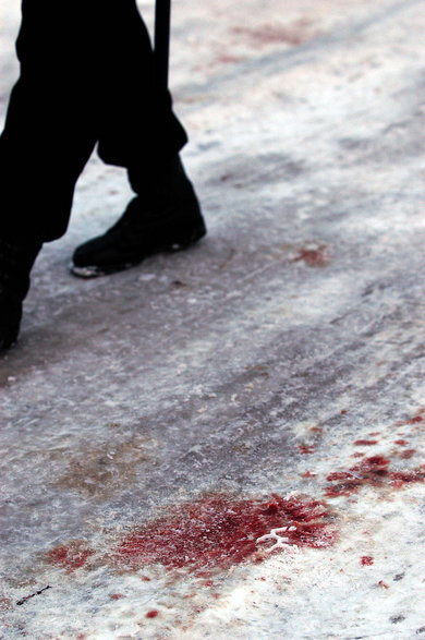 Ślady krwi na śniegu, w miejscu, gdzie zginął jeden z policjantów uczestniczących w starciu z dwoma bandytami ukrywającymi się w domu w Magdalence