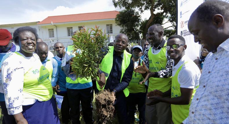 Kyakulya (centre) planting a tree to mark Human Rights Defenders Day. Photos by Ambrose Watanda