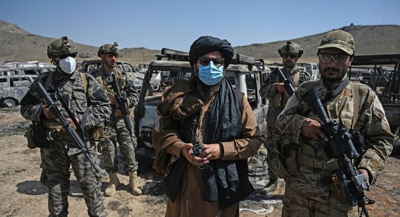 Members of the Taliban Badri 313 military unit stand beside damaged and discarded vehicles parked near the destroyed Central Intelligence Agency (CIA) base in Deh Sabz district northeast of Kabul on September 6, 2021 after the US pulled all its troops out of the country.
