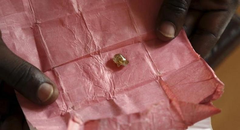 A man displays a rough diamond, from the Boda region, for sale in Bangui May 1, 2014.    REUTERS/Emmanuel Braun