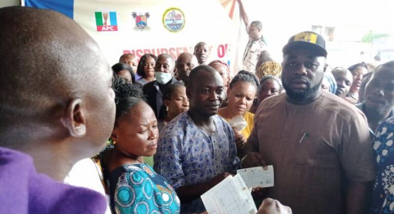 The Chairman, Agboyi-Ketu LCDA, Dele Oshinowo presenting a cheque of N165,000 to one of the victims of October #EndSARS protest in Ketu on Thursday, Dec. 3, 2020 (NAN).