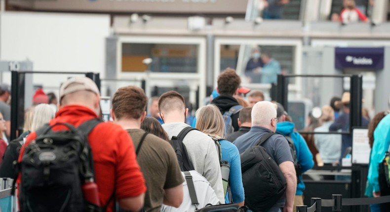 Travelers queue up at the north security checkpoint in the main terminal of Denver International Airport, Thursday, May 26, 2022, in Denver.