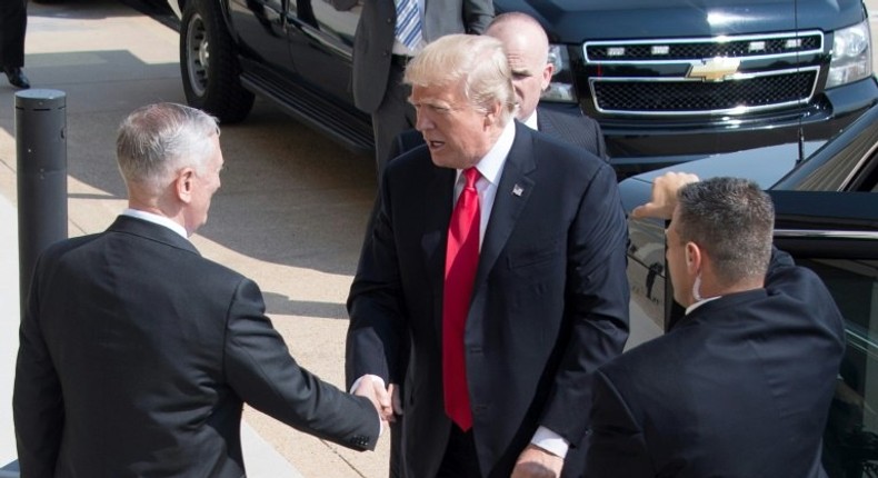 US President Donald Trump (C) marked the six-month point of his president with a visit to the Pentagon, shaking hands with his Defense Secretary James Mattis (L)