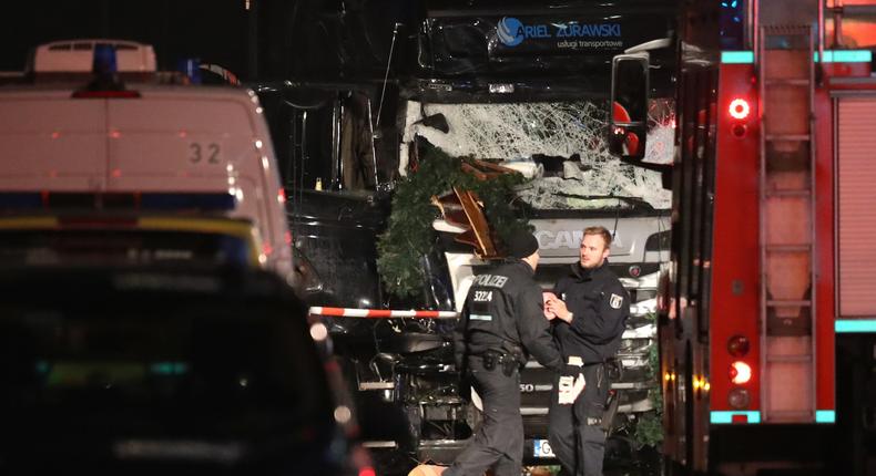 Security and police officers seen near the damaged truck after it plowed through a Christmas market on Monday night in Berlin.