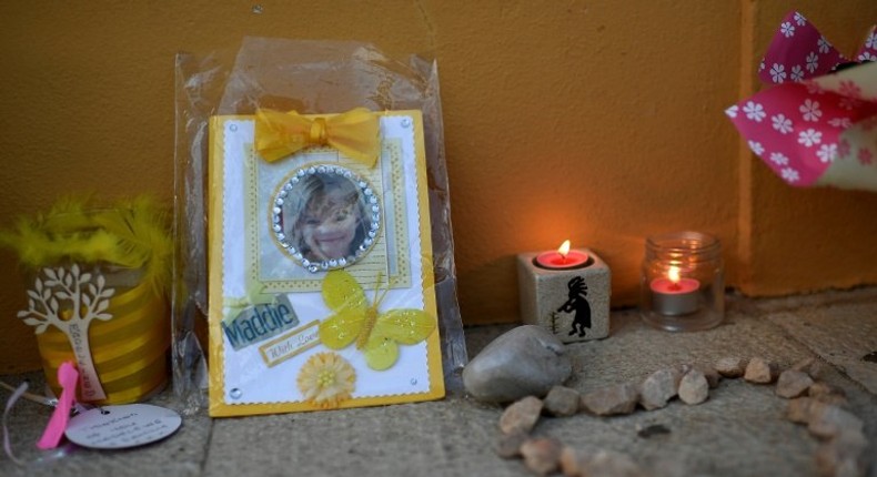 Candles and a photograph of Madeleine McCann are placed outside the church in Praia da Luz on May 3, 2017 to mark 10 years since the British girl's mysterious disappearance in the Portuguese seaside village