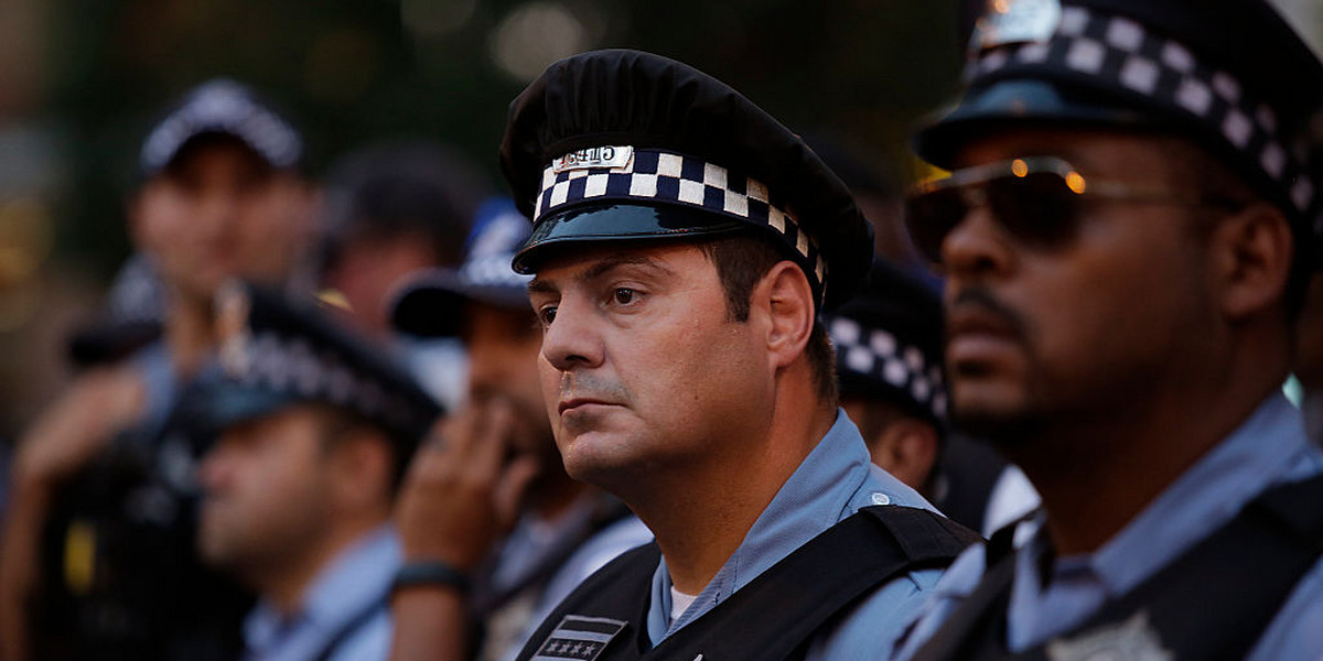 Police officers watching as demonstrators protested the fatal police shooting of Paul O'Neal on August 7 in Chicago.