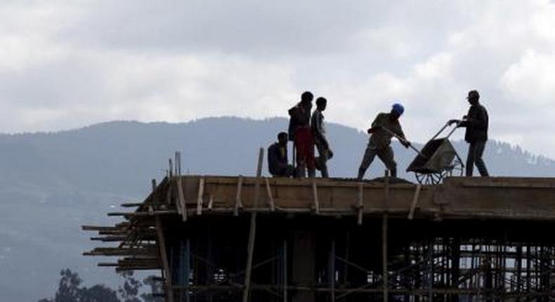 Construction workers work on the roof of a new building at the Mercato market in Addis Ababa September 11, 2015.